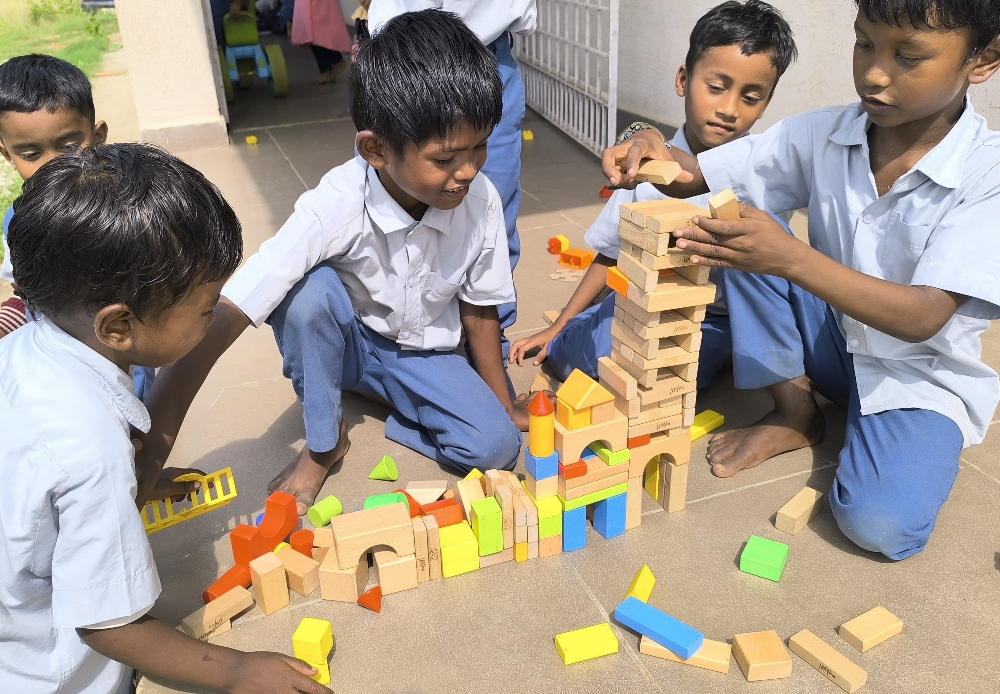 Children building with wooden blocks together