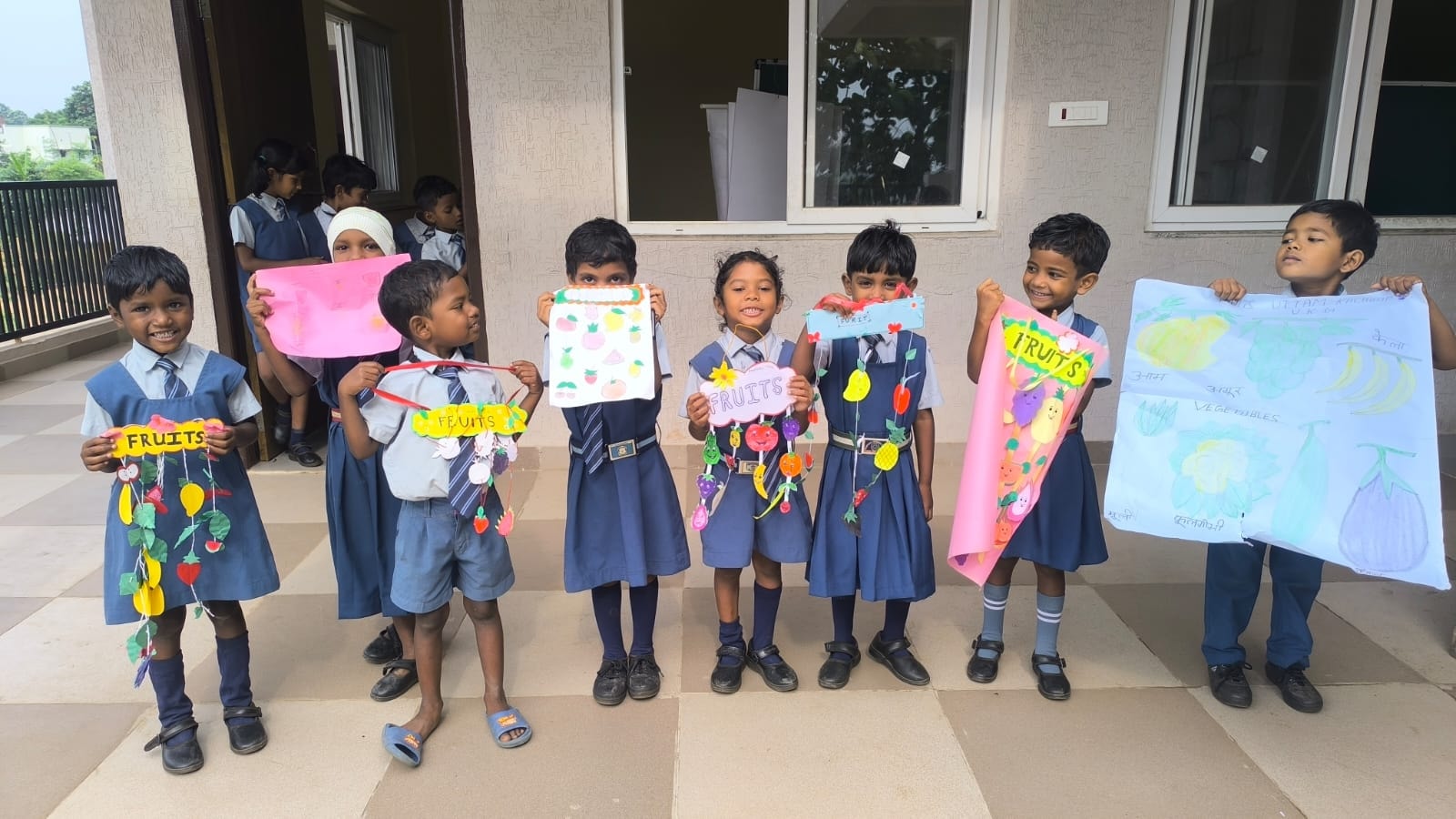 Children displaying colourful handmade fruit artwork