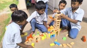 Children building with wooden blocks outdoors